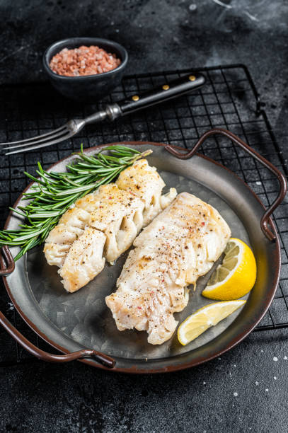 istock Roast Fillets of codfish, cooked cod fish meat. Black background. Top view 1464122781