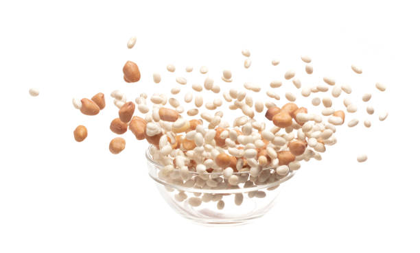 Mix white peanut beans fall down explosion, several kind bean float explode in glass bowl. Dried white peanut mixed beans splash throwing in Air. White background Isolated high speed shutter, freeze mezcle frijoles de maní blancos caen por la explosión, varios tipos de flotador de frijoles explotan en un recipiente de vidrio. frijoles mixtos de maní blanco seco salpicando en el aire. fondo blanco obturador aislado de alta velocidad, congelación