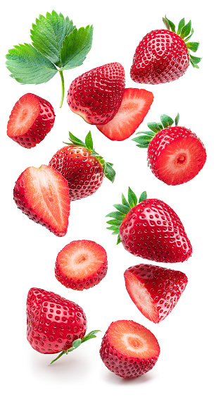 Strawberry, strawberry cuts and leaf levitating on white background.