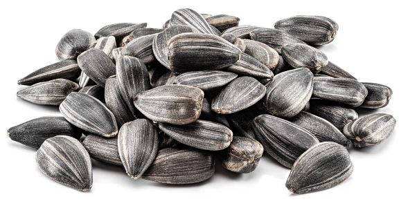 Stock photo showing close-up view of some white sunflower seeds piled high in a brown dish, against a woodgrain background. Raw sunflower seeds are considered to be a very healthy snack food and are high in vitamin E, selenium, antioxidants and protein, boasting a list of health benefits and may aid lower blood pressure.