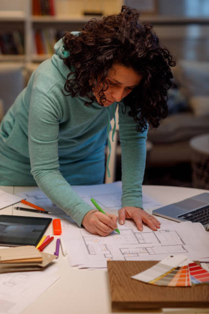 istock Female Interior Designer Working Late At Home Amending Interior Design Plans 1464127371