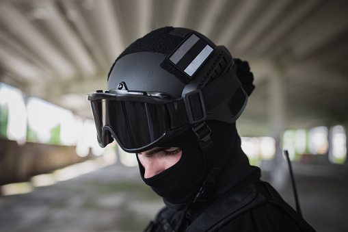 Close-up of a young man standing in special force gear with protective helmet