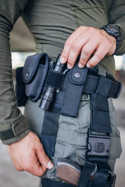 primo piano di un giovane in piedi in equipaggiamento tattico - tactical flashlight foto e immagini stock