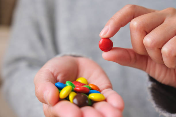 istock Closeup image of hands holding and picking colorful chocolate candy 1464132485