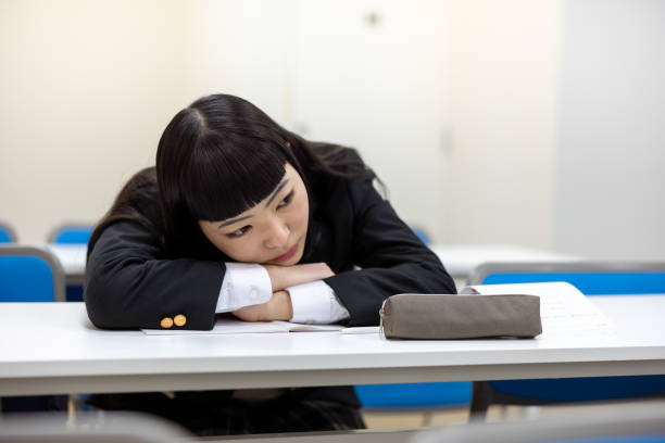 High school girl studying in classroom - tired
