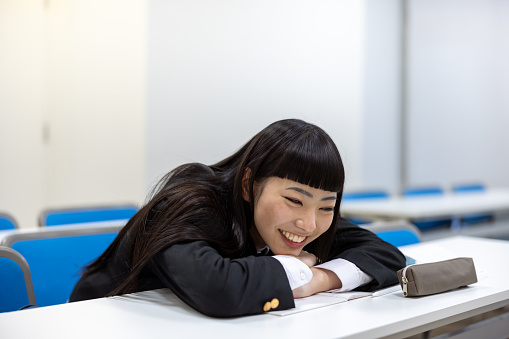 High school girl studying in classroom - smiling