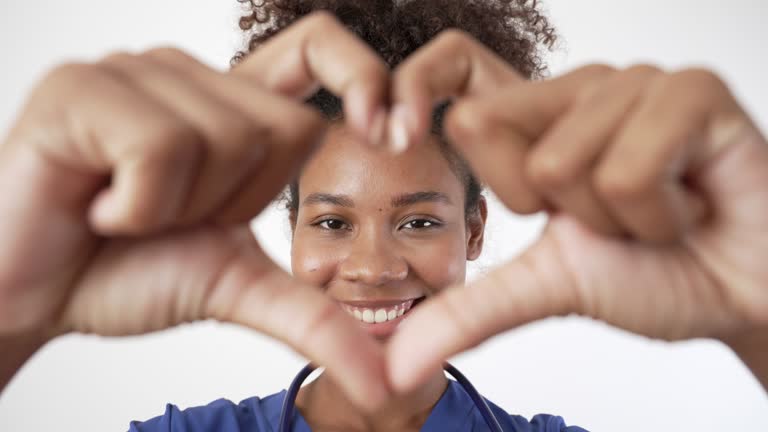 Doctor black woman showing hands sign heart shape.