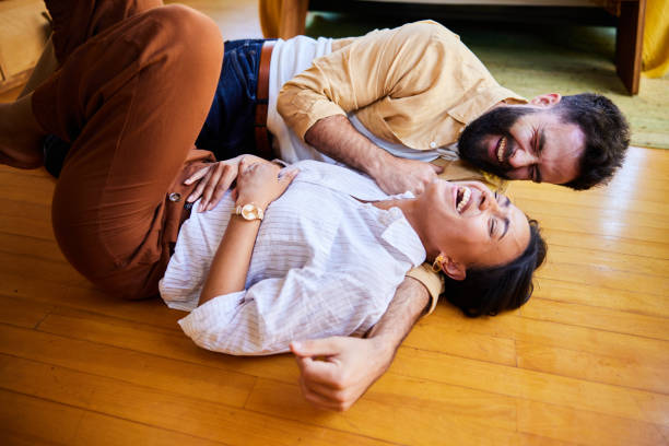 istock Young couple lying together on their floor and laughing 1464134391
