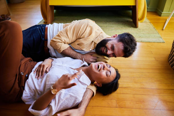 istock Young couple lying on their floor and laughing together 1464134946