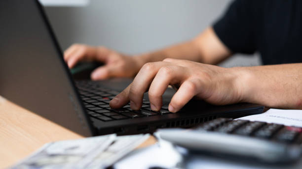 istock Close-up Man paying bills from laptop 1464136056