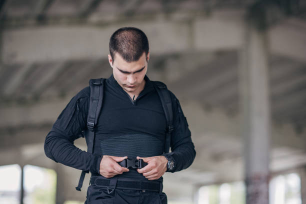 istock Young man putting military tactical equipment 1464138126