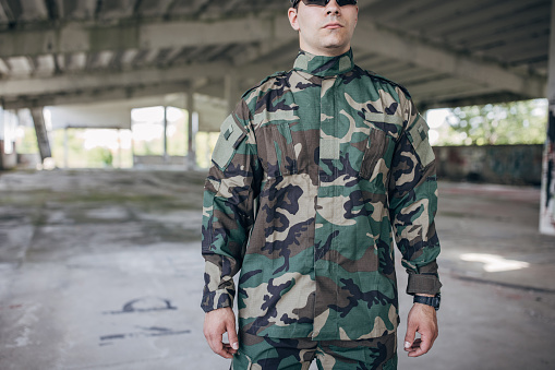 Young man standing in military clothing in warehouse