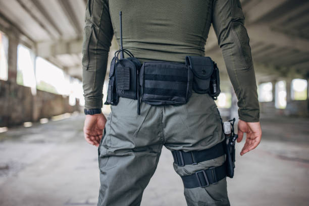 istock Young man standing in tactical gear with gun holder 1464140353