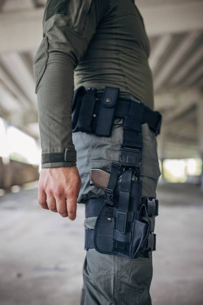 istock Young man standing in tactical gear with gun holder 1464140407