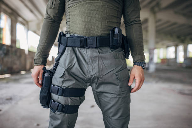 istock Young man standing in tactical gear with gun holder 1464140746