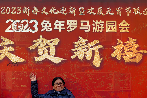Rome, Italy - February 5, 2023: The Chinese community celebrate their New Year party in the Italian capital. A woman lets herself be photographed in front of the decorated 2023 calendar sign.