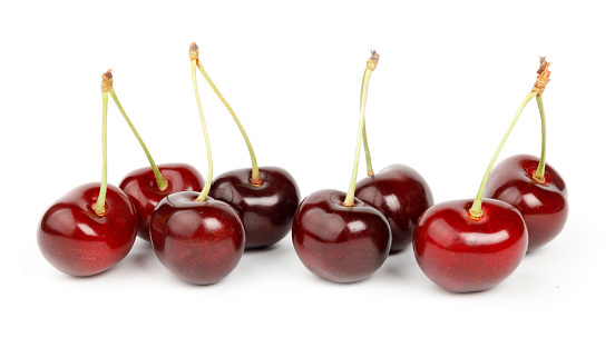 Dark red ripe cherries on a white background.