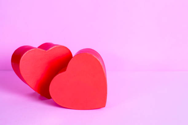 istock two red hearts in love on pink background 1464146784