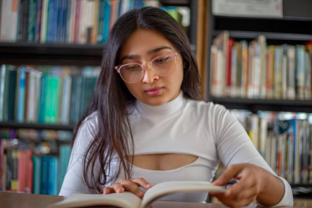 istock Girl doing homework in the library 1464147229