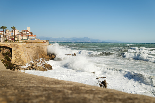 Winter storm waves crash on Antibes old town ramparts. Mediterranean coast between Nice and Cannes, South of France.