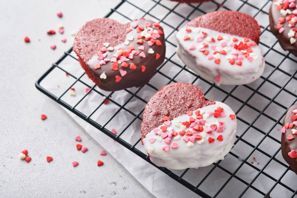 red velvet or brownie cookies on heart shaped in chocolate icing on a pink romantic background. dessert idea for valentines day, mothers or womens day. tasty homemade dessert. cake for valentines day - valentine candy fotos imagens e fotografias de stock