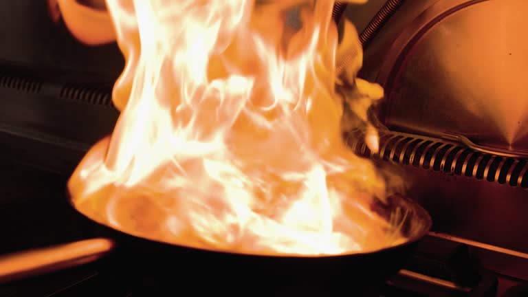 Cook fries vegetables in frying pan. Flying vegetables. Cooking on fire and coal. Slow motion. Close-up view