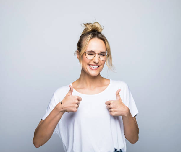 istock Smiling woman showing thumbs up while winking 1464158954