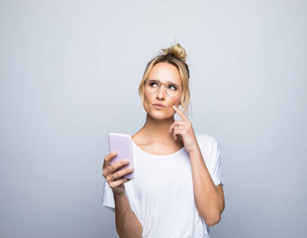 istock Thoughtful woman holding smart phone touching cheek 1464159039