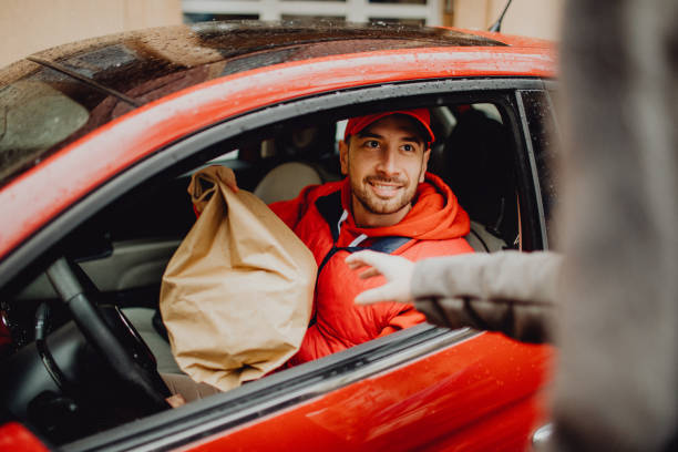istock Joyful delivery man delivering an order to a customer 1464159751