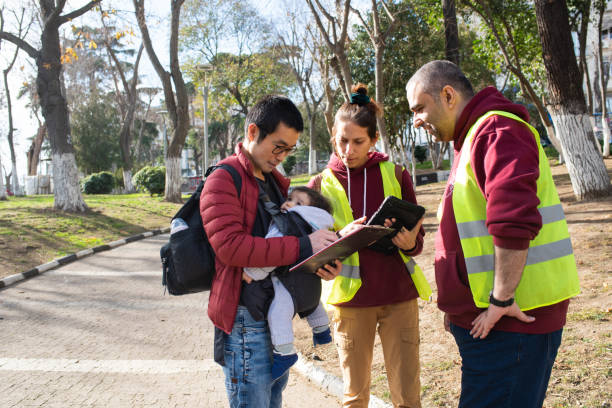 Volunteers collecting signatures A mid adult man with his baby in a carrier, talking to volunteers collecting signatures for a petition. petition stock pictures, royalty-free photos & images