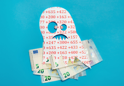 Conceptual image of Euribor as in scary monster floating above Euro money bank notes on blue studio background.