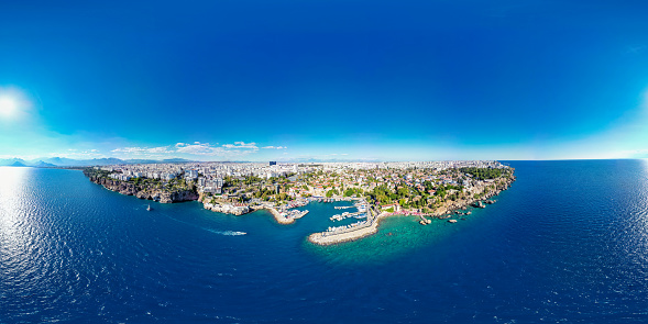 Antalya, Turkey - September 10, 2022: Antalya Harbor and castle,  aerial drone view. Tourists, sailboats and pedestrians in the harbour