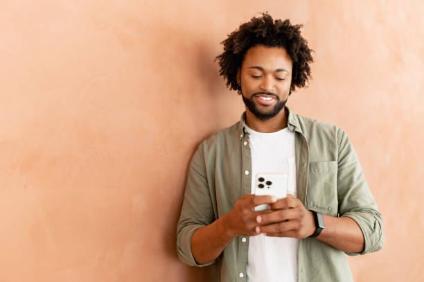 istock Positive african-american male employee using smartphone for online communication 1464167792
