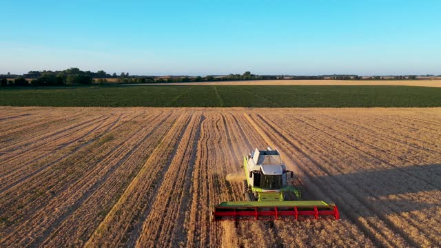 Aerial view of a tractor farming in an agricultural field in Belgium.
