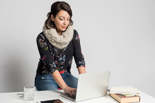 Smiling fashion designer working on laptop at creative office