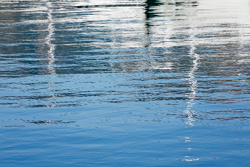 Rippled sea water with reflections of yachts moored in marina at Gocek, Turkey