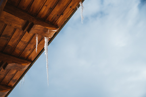 Icicles and Snow Overhanging a Roof