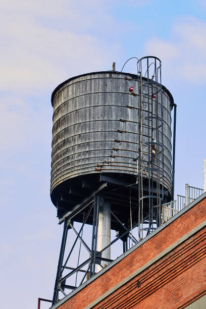 istock Grey Water Tower with Ladder on Red Brick Building in NYC 1464178470