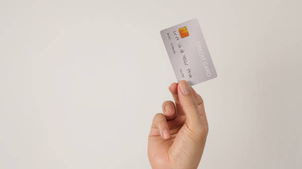 istock Hand is hold silver credit card on white background. 1464179280