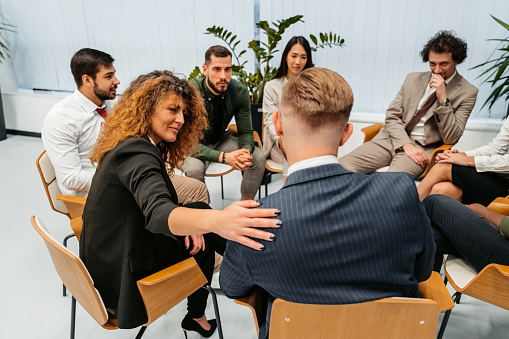 Group of business colleagues having a group therapy session in the office at work.