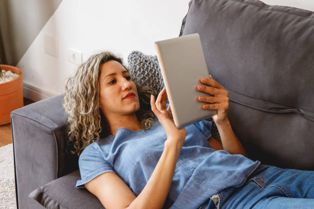 istock woman relaxing reading on a tablet 1464185551