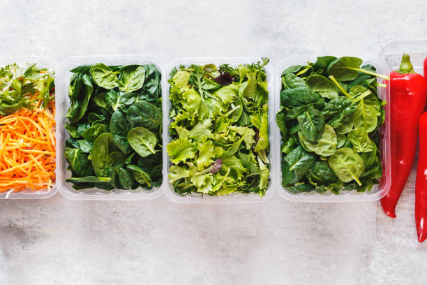 istock Various salad leaves and vegetables  in plastic containers on rustic background 1464188334