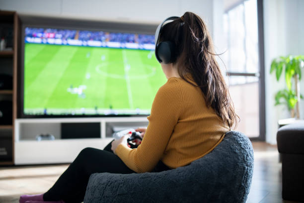 istock Woman playing football game on gaming console. 1464189893