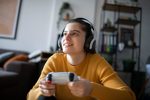 Young woman at home having fun playing video games.