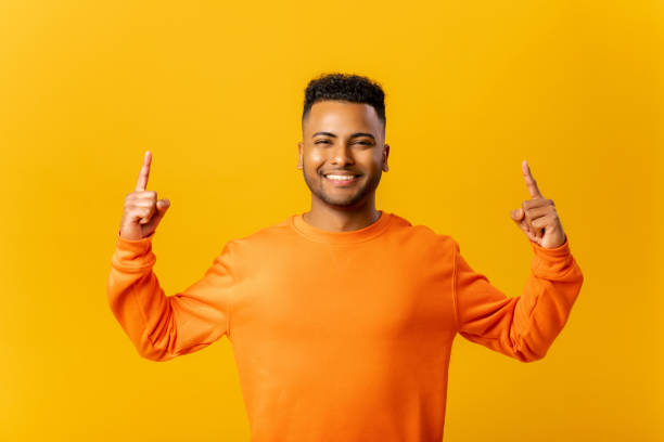 istock Attractive indian man with overjoyed facial expression pointing up with both fingers, presenting copy space 1464190246