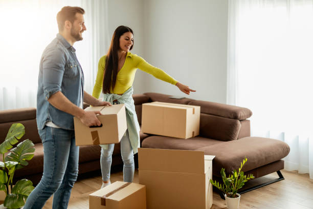istock Smiling couple unpaking boxes in new home 1464190422