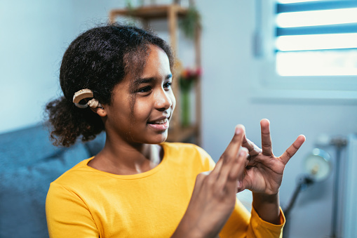 Hearing Aid in Young Girl's Ear. Teenager girl wearing a hearing aid.