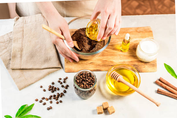 женщина смешивания ингредиентов подготовки кофе скраб для лечения кожи - massage stamps стоковые фото и изображения