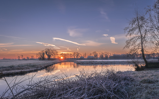 Dutch landscape, fields, water, trees in the distance, frost, an idyllic picture, peace and quiet.