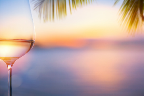 a glass of white wine at a tropical beach bar; Beautiful tropical sea sunset